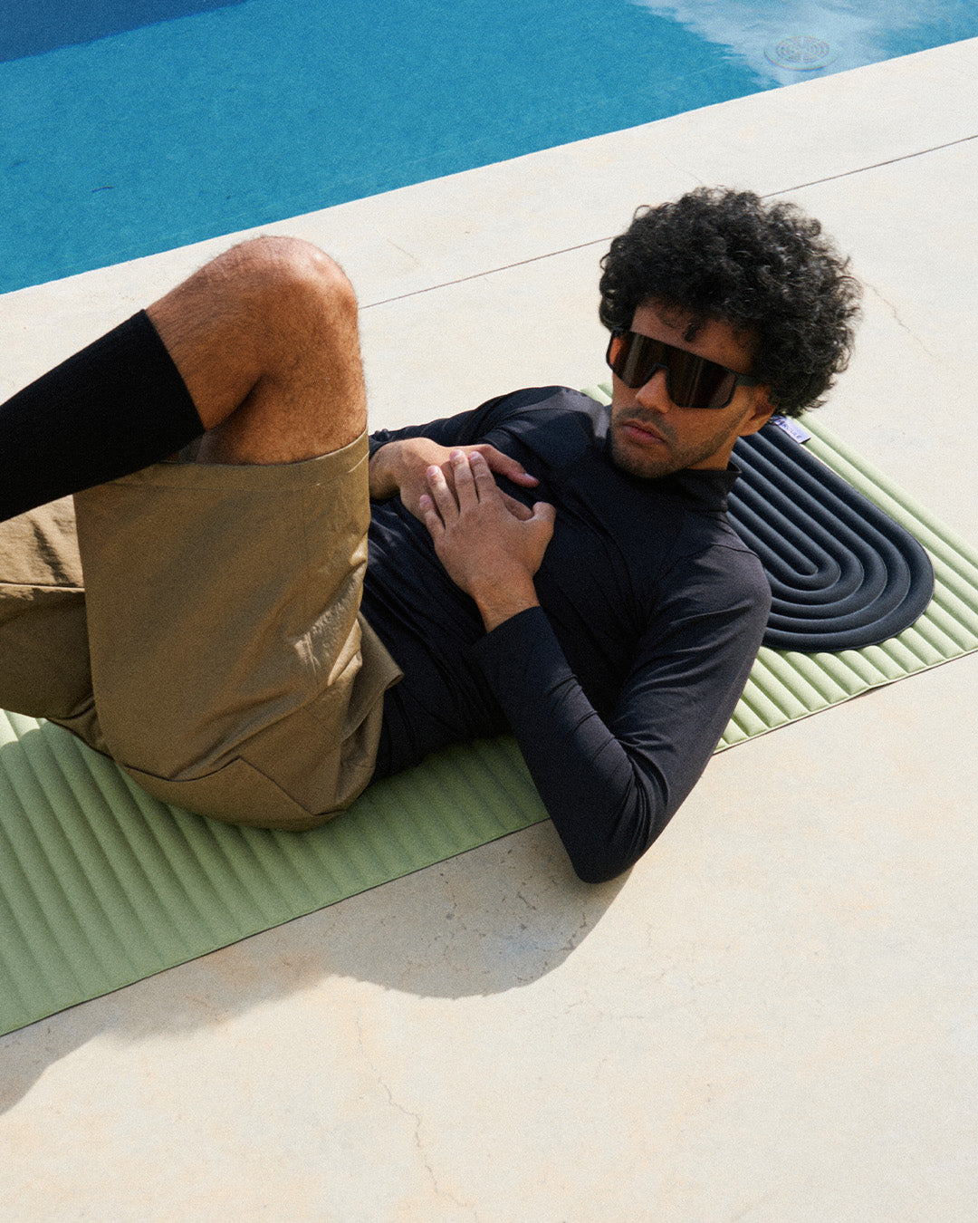 Mini tapis de sol pad de confort de la marque hercule studio modèle galé couleur outrenoir posé sur le tapis d'exercice archy couleur pistache avec mannequin allongé dessus