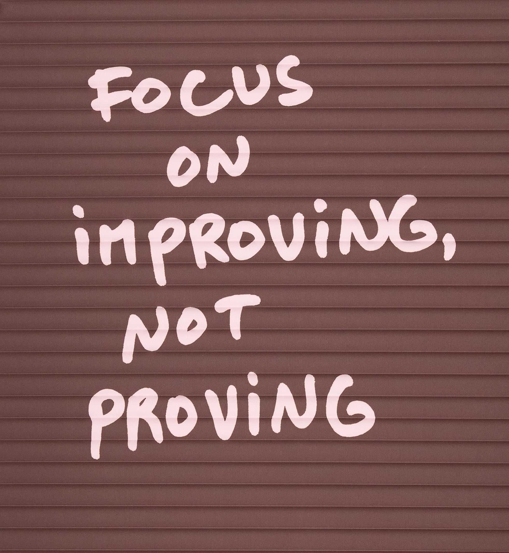 Zoom sur le relief du tapis de sport archy avec la citation de thomas lélu "focus on improving, not proving"