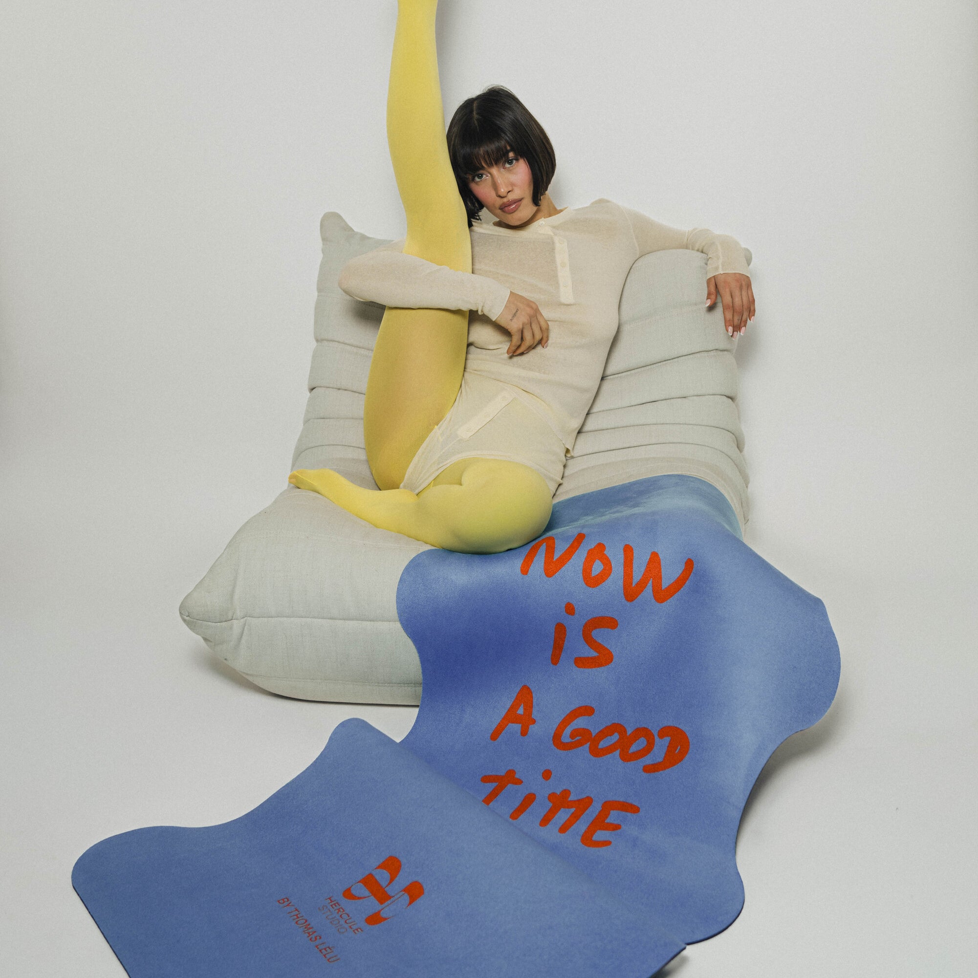 Mise en situation lifestyle design du tapis de yoga Hercule Studio x Thomas Lélu avec la citation "Now is a Good time" imprimée dessus