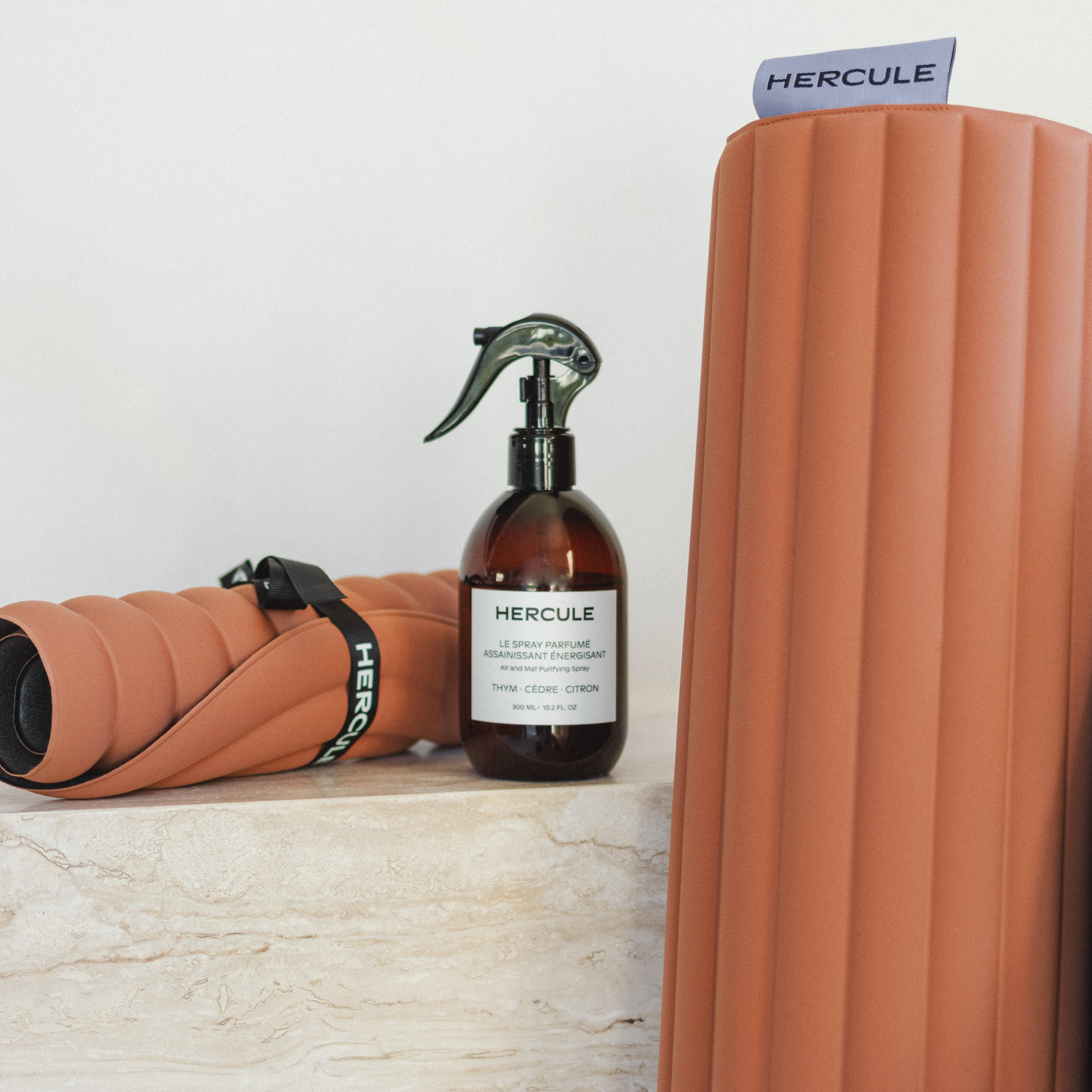 Set essentiel avec tapis de sport Archy, mini tapis de sport Galé couleur Terre cuite et spray parfumé de la marque Hercule Studio photo lifestyle avec marbre