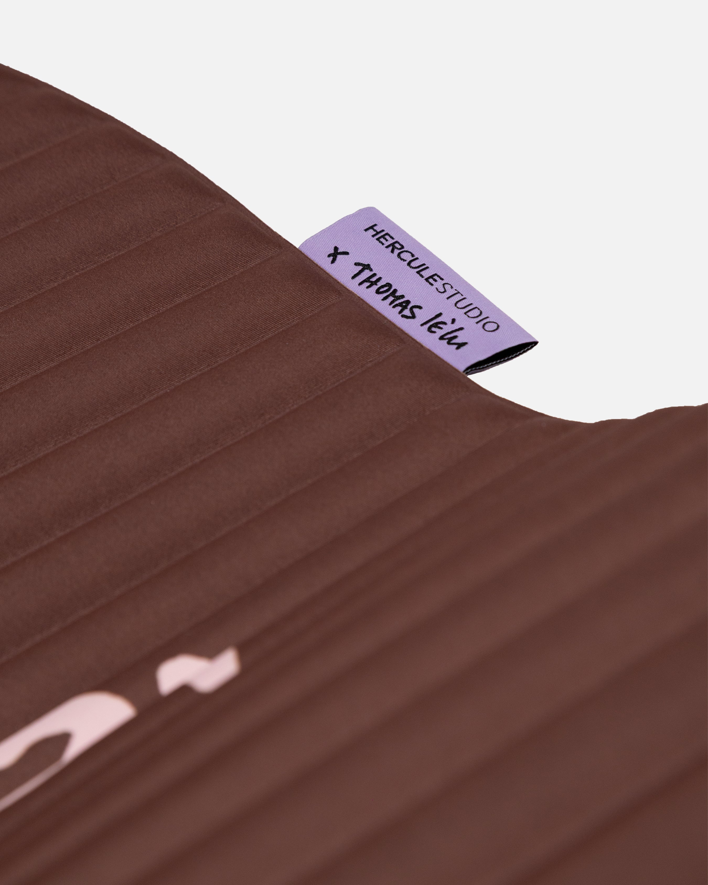 Close-up on the custom Hercule Studio x Thomas Lélu label, premium textile finish of the sport mat