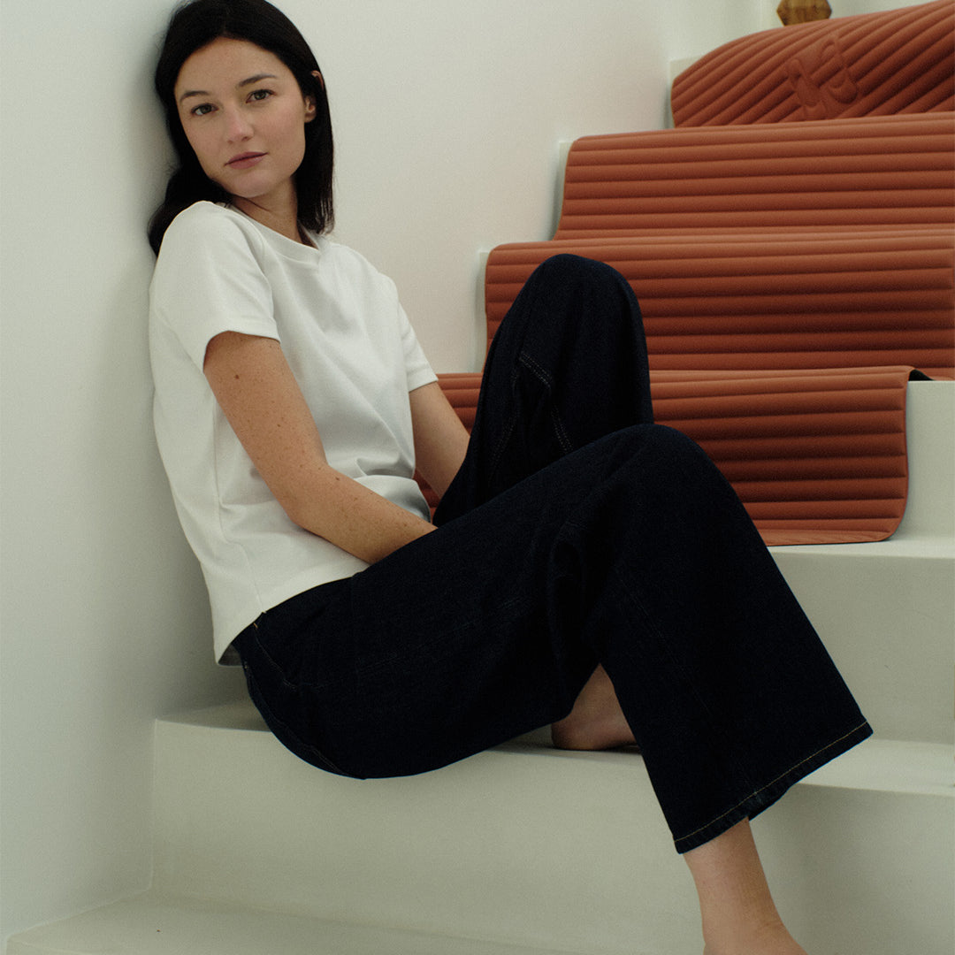 Tapis de sol pour le fitness le yoga et le pilates de la marque hercule studio modèle archy couleur terre cuite photo du tapis dans les escaliers avec mannequin