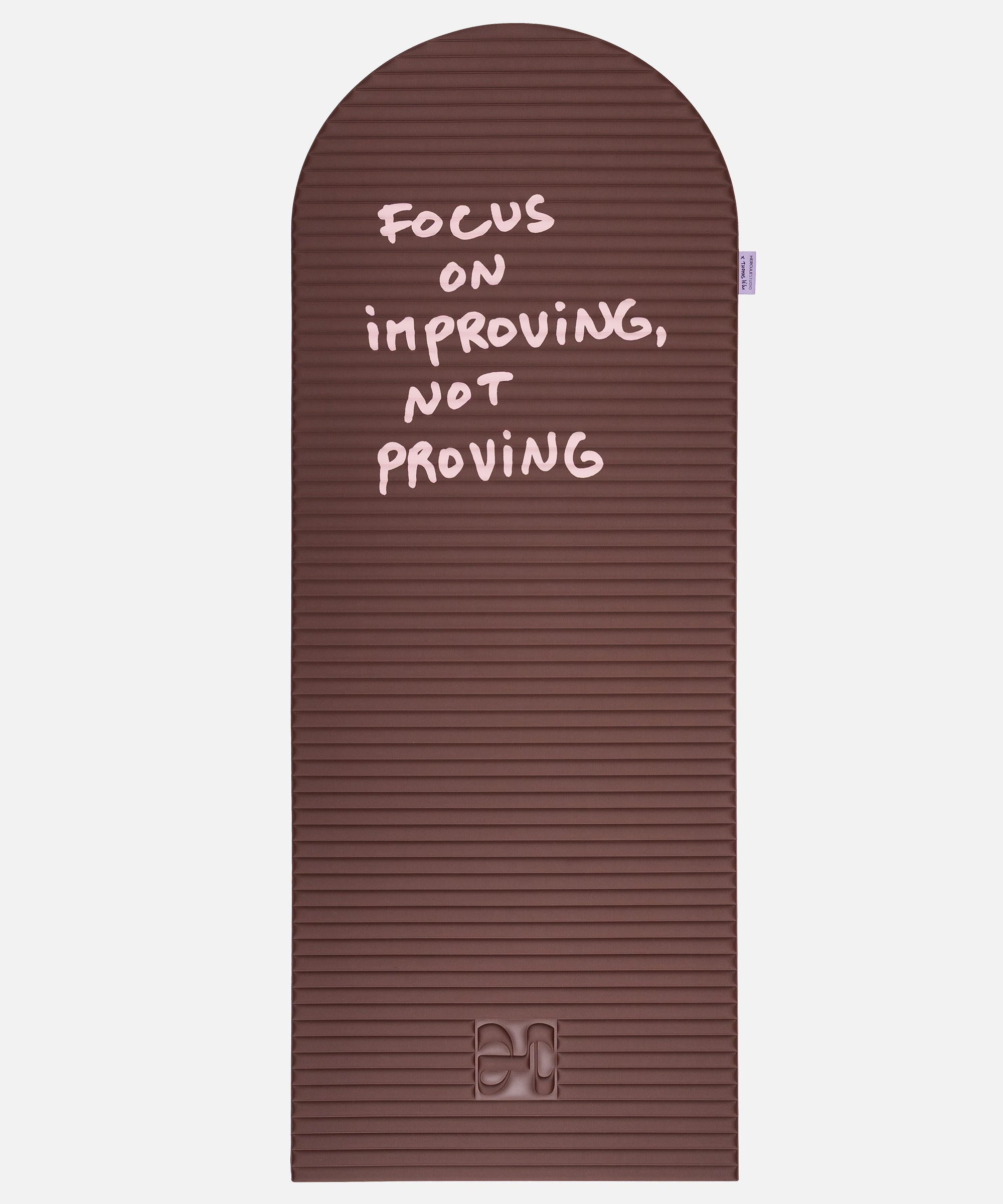 Hercule Studio x Thomas Lélu Limited Edition Exercise Mat, brown designer floor mat featuring a pink quote reading “focus on improving not proving,” an artistic collaboration for fitness, Pilates, and stretching, unfolded view